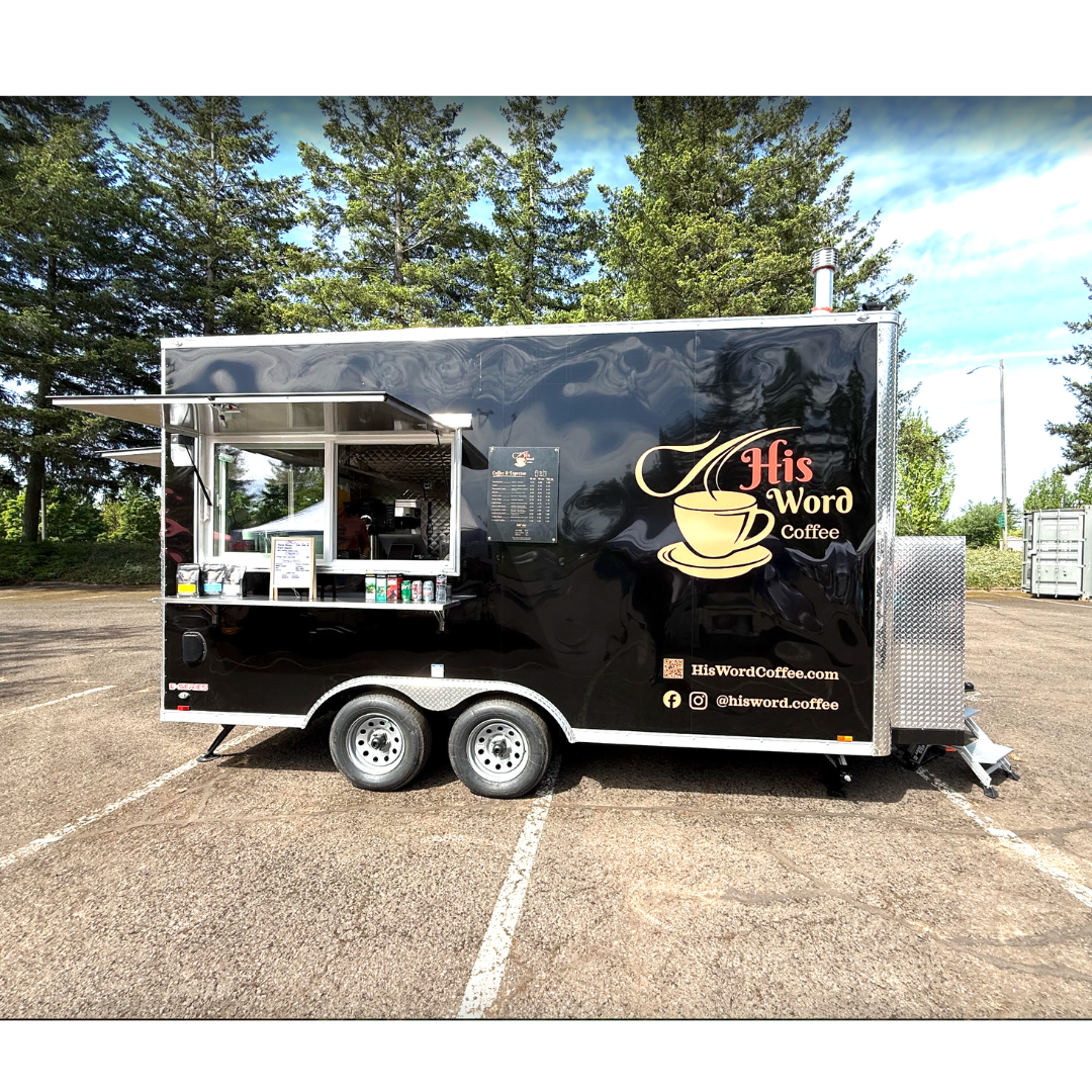 His Word Coffee black coffee trailer with service window open, menu board, and logo in a parking lot with trees - His Word Coffee