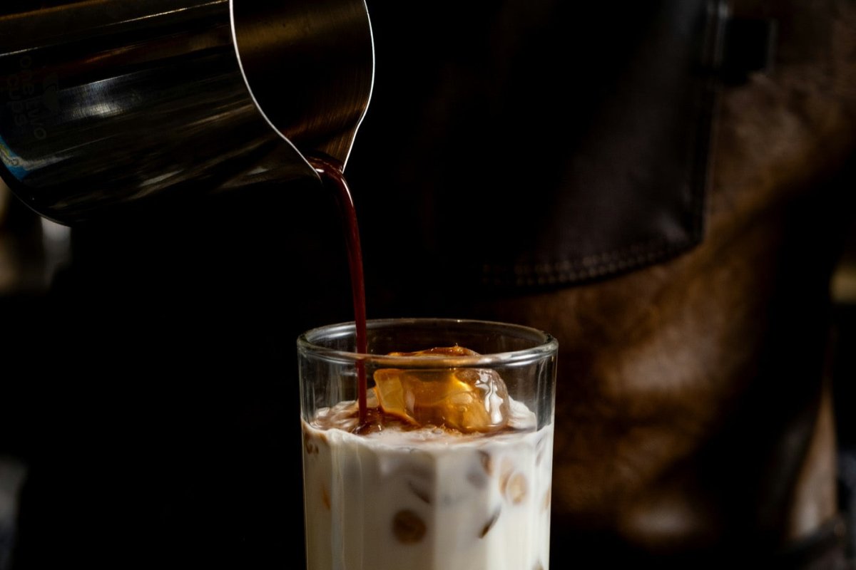 Fresh brewed coffee beside an open notebook in warm morning light