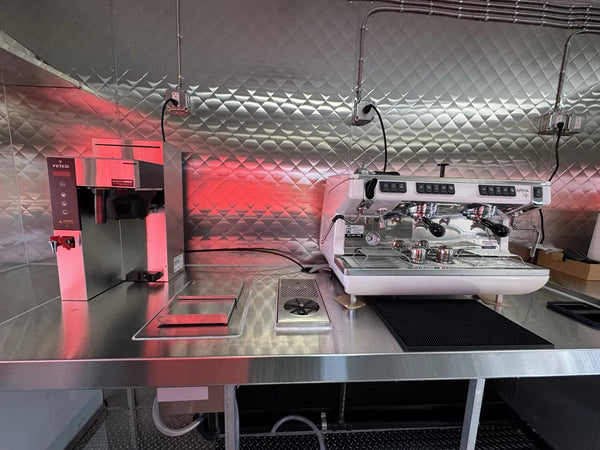 Professional espresso machine and stainless work area inside the His Word Coffee trailer